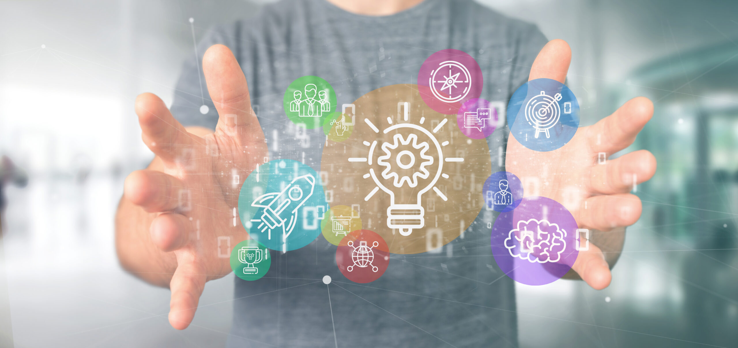 Un empresario sostiene una nube de íconos coloridos de startups y datos digitales, representada en un entorno tecnológico con elementos binarios en 3D